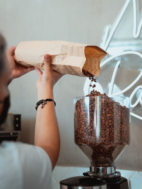 Foto af Los Muertos Crew: https://www.pexels.com/photo/photo-of-person-pouring-coffee-beans-on-a-coffee-grinder-7487361/